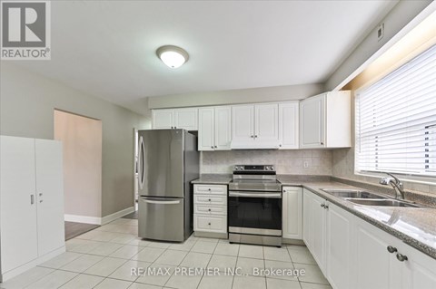A kitchen with white cabinets and a stainless steel refrigerator.