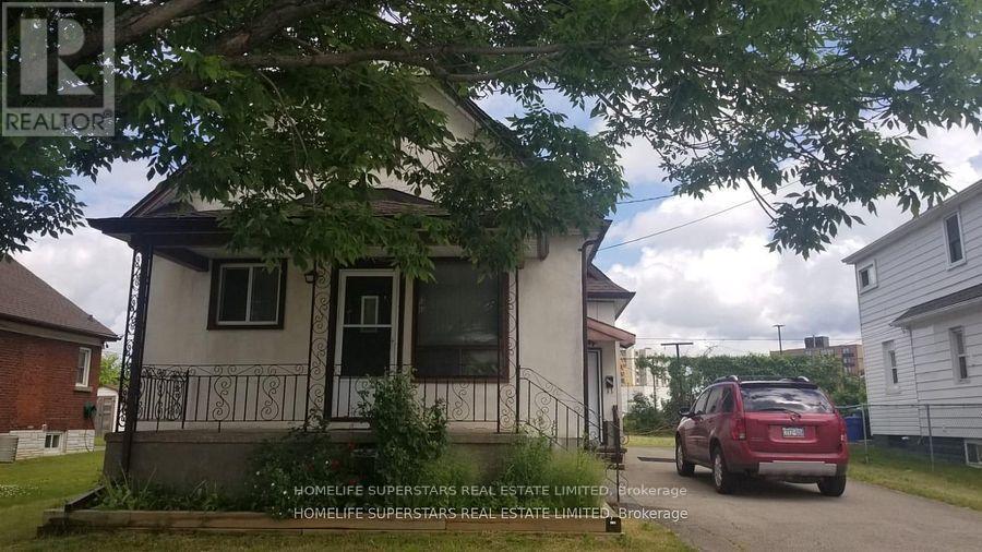 A small house with a sign that says REALTOR in front of it.