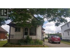 A small house with a sign that says REALTOR in front of it.