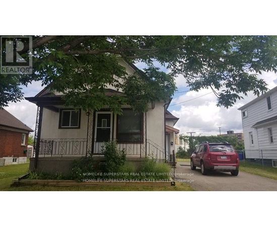 A small house with a sign that says REALTOR in front of it.