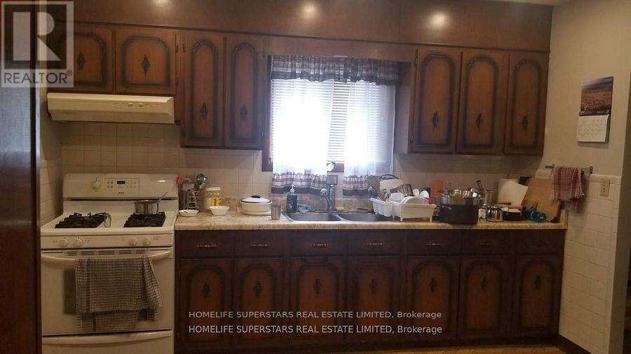 A kitchen with wooden cabinets and a white stove top oven.
