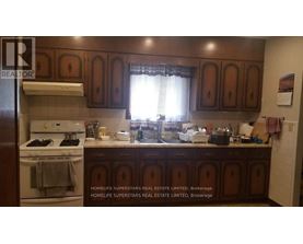 A kitchen with wooden cabinets and a white stove top oven.