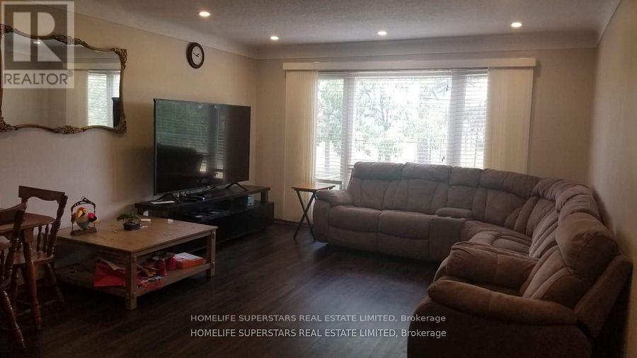 A living room with a brown couch and a flat screen TV.
