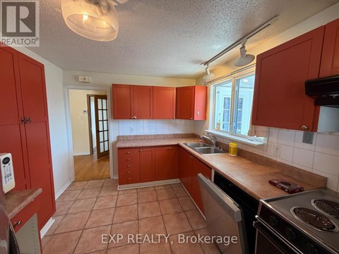 A kitchen with red cabinets and a stove top oven.