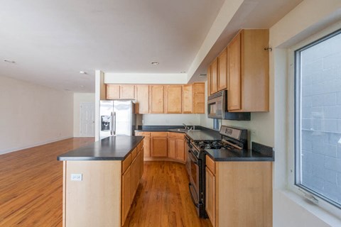 a kitchen with wooden cabinets and black counter tops
