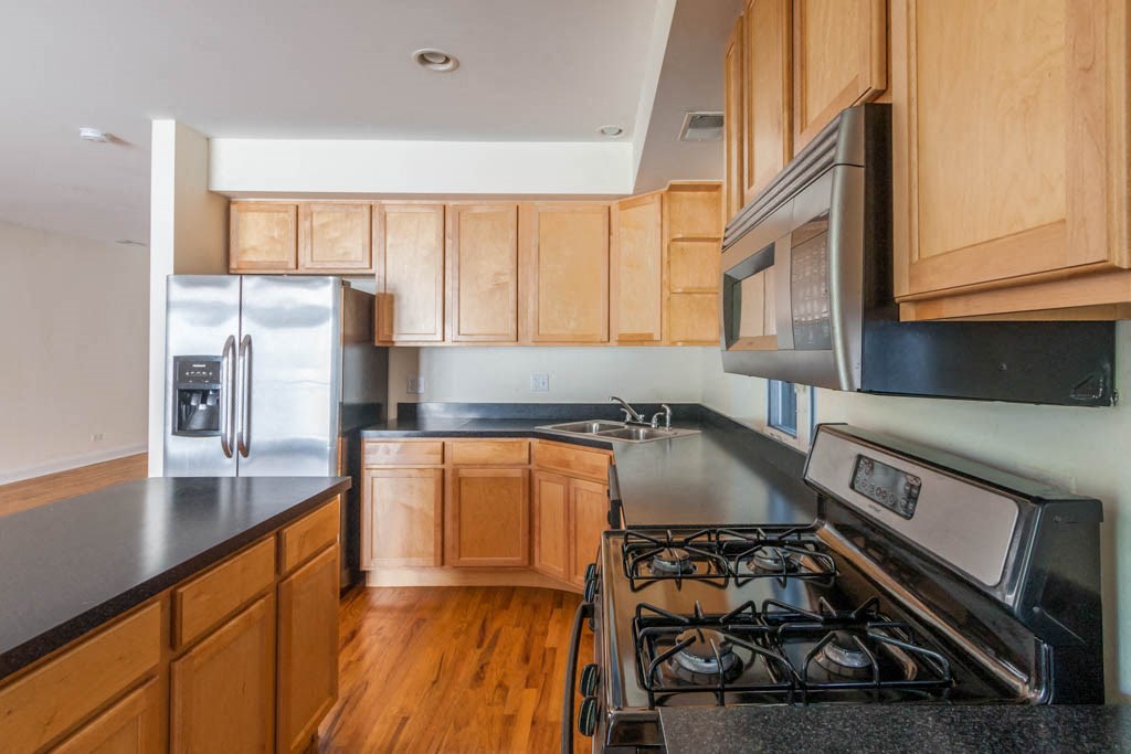 a kitchen with wooden cabinets and a stove and a refrigerator