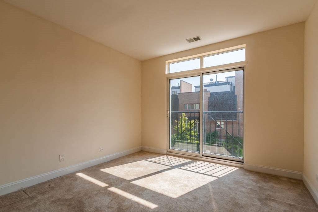 a living room with a large window and a door to a balcony