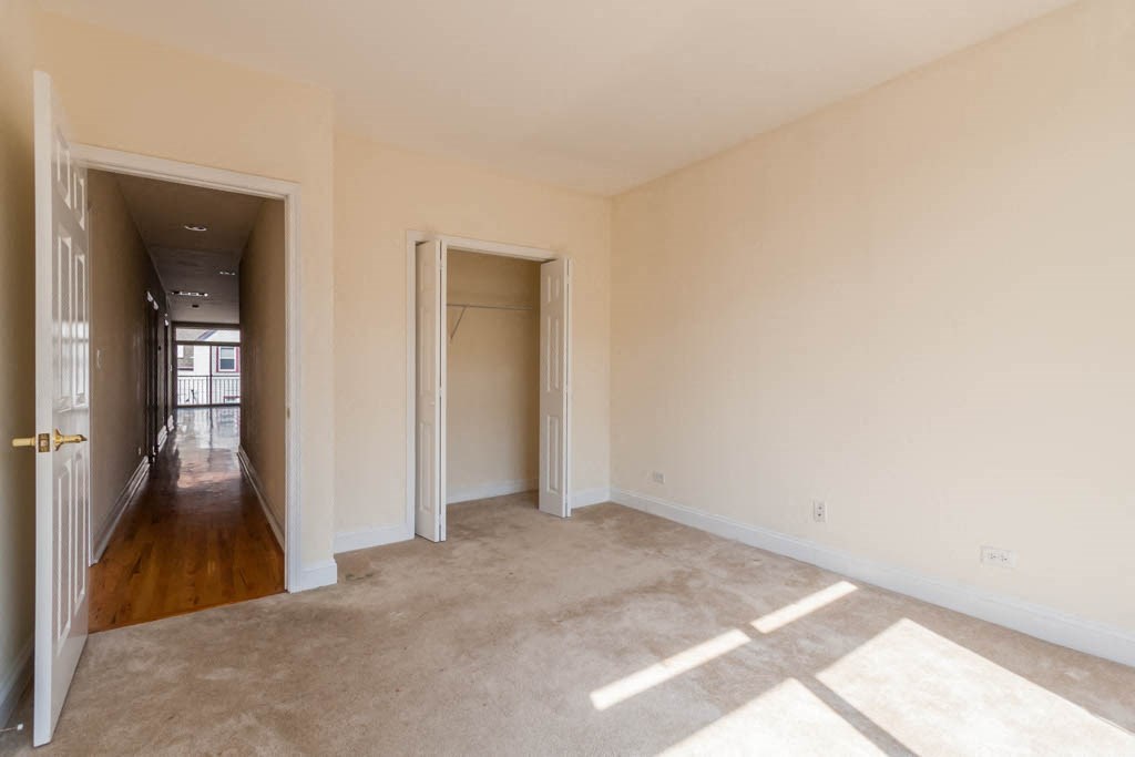 a empty room with a hallway and a door to a closet