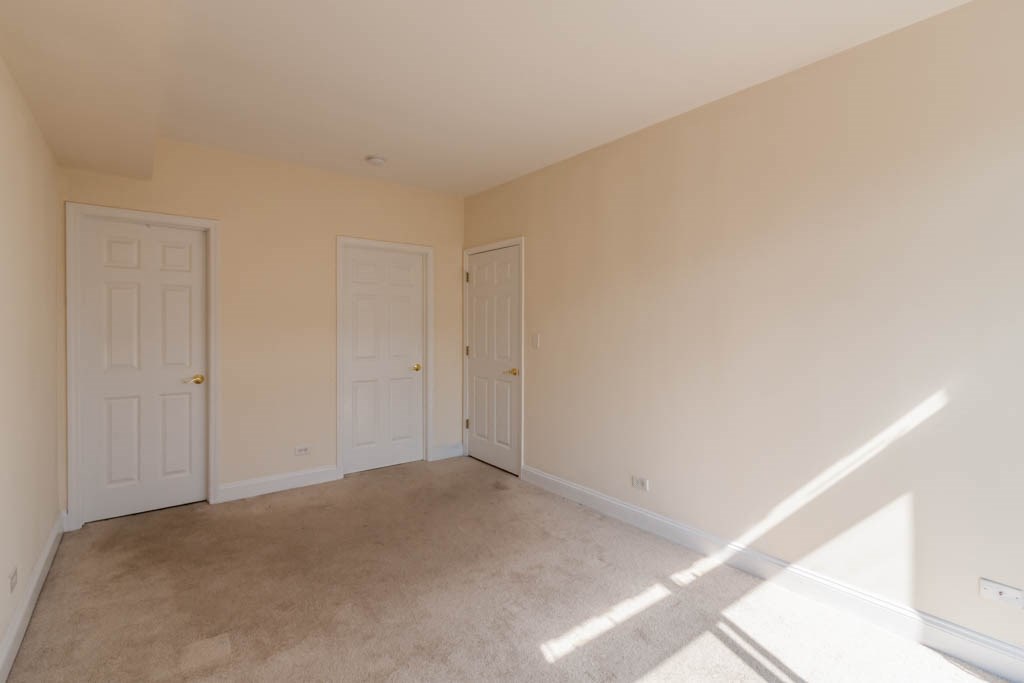 a bedroom with two doors and a carpeted floor
