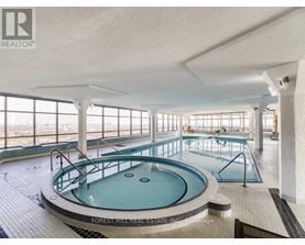 A large indoor swimming pool with a hot tub in the middle.