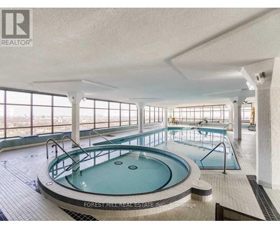 A large indoor swimming pool with a hot tub in the middle.