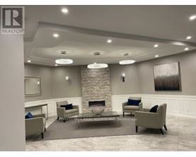 A living room with a stone fireplace and a grey couch.