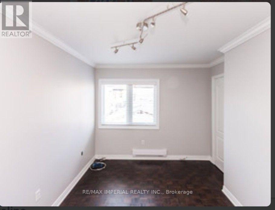 A room with a window and a brown carpet.