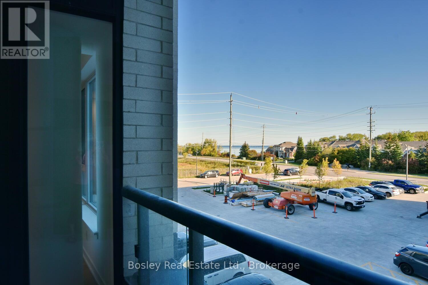 A parking lot with cars and a building with a Realtor sign.