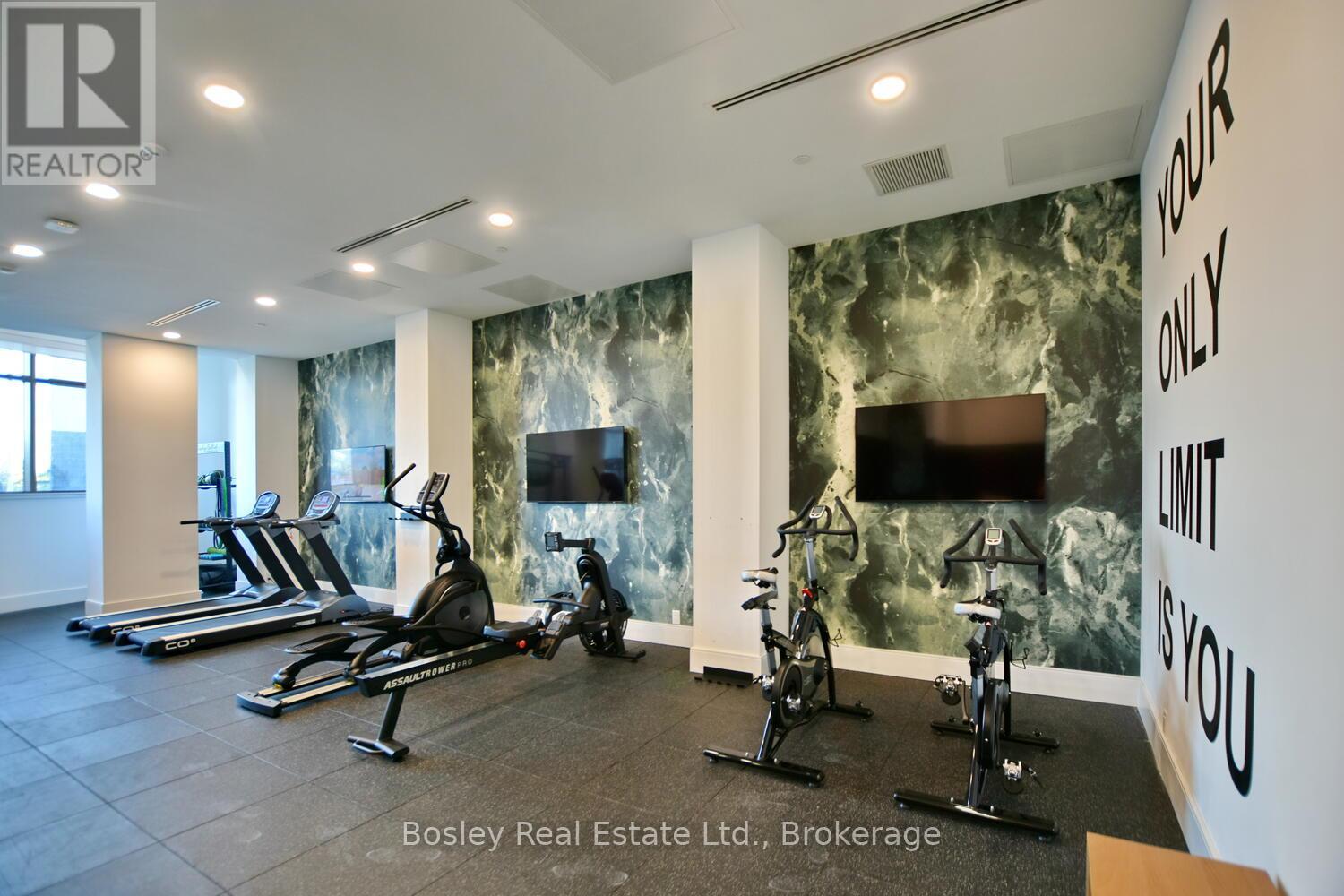 A gym with a row of treadmills and exercise bikes.