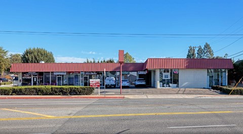 A building with a red roof and a sign that says "The Bank" in front of it.