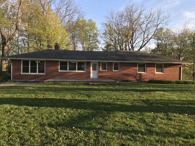 A red brick house with a white door and windows.