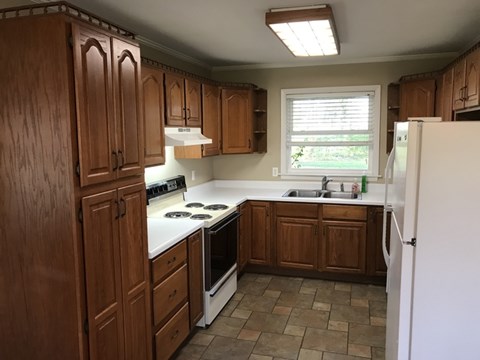 A kitchen with wooden cabinets and a white refrigerator.