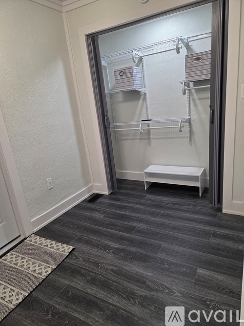 A walk-in closet with a bench and shelves.