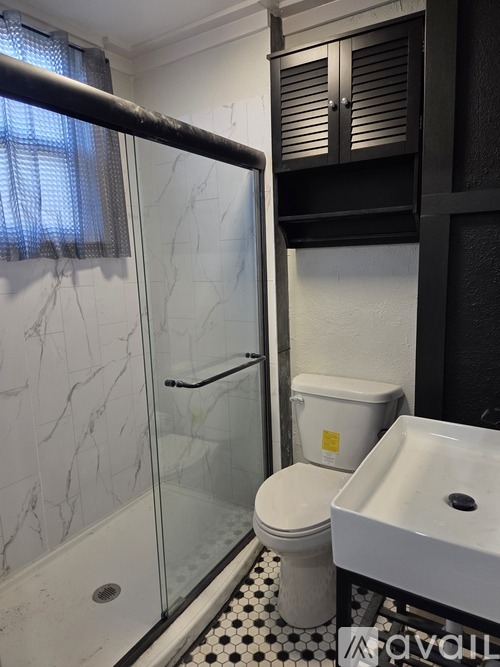 A bathroom with a toilet, sink, and shower.