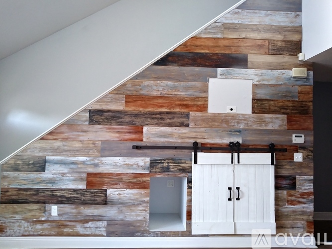 A wooden wall with a white door and a white cabinet.
