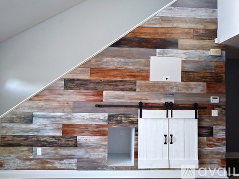 A wooden wall with a white door and a white cabinet.