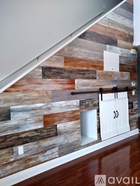 A wooden wall with a white door and a white staircase.