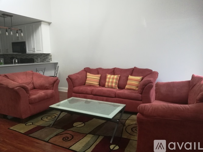 A living room with red furniture and a glass table.