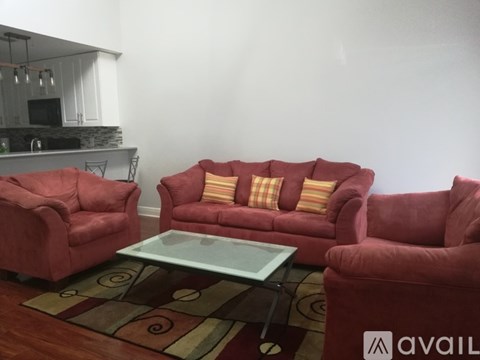 A living room with red furniture and a glass table.