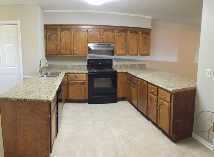 A kitchen with wooden cabinets and granite countertops.