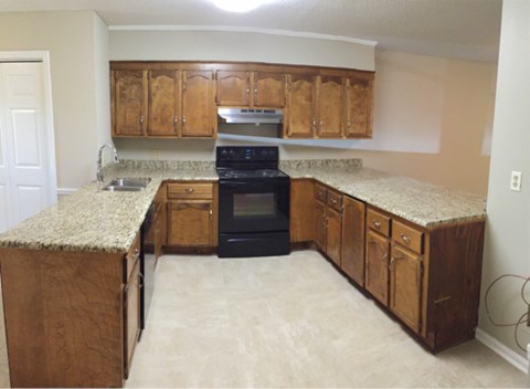 A kitchen with wooden cabinets and granite countertops.