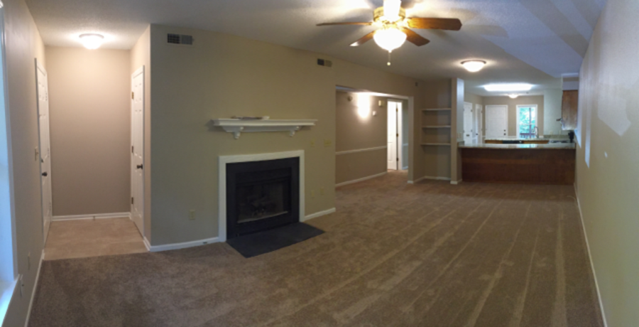 A room with a fireplace and a ceiling fan.
