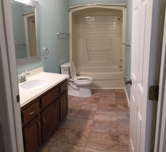A bathroom with a toilet, sink, and shower.
