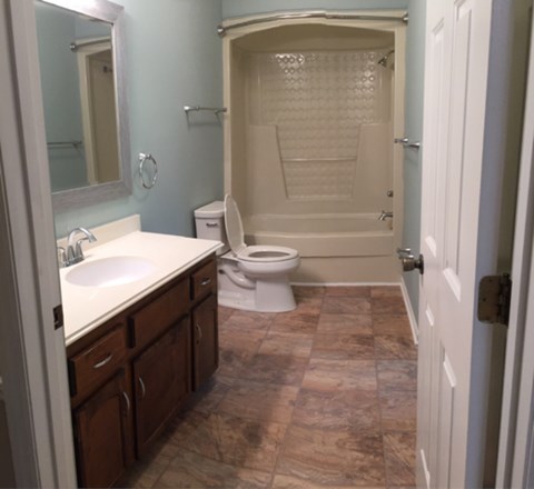 A bathroom with a toilet, sink, and shower.