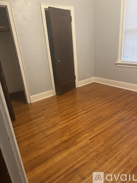 A room with wooden flooring and a door.