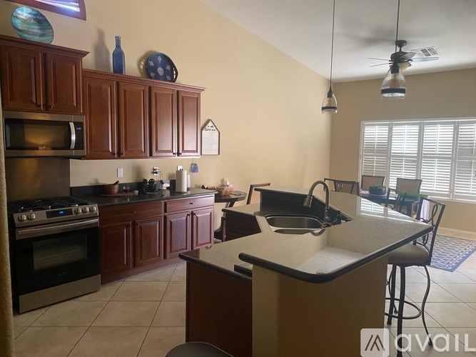 A kitchen with brown cabinets and a black stove top oven.