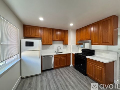 A kitchen with wooden cabinets and a white refrigerator.