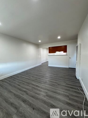 A room with wooden flooring and white walls.