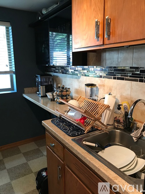 A kitchen with a checkered floor and a sink.