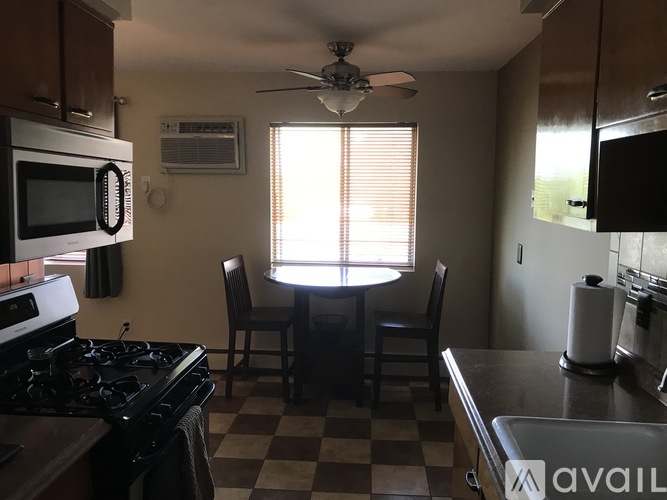 A kitchen with a checkered floor and a window with blinds.