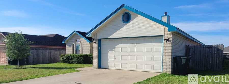 A house with a blue roof and a garage door is for sale.