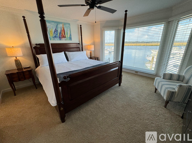 A bedroom with a four poster bed and a ceiling fan.