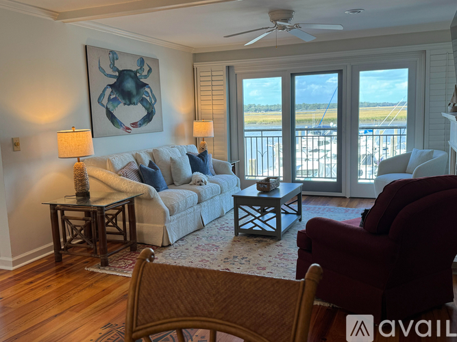 A living room with a couch, chairs, and a painting of a crab.