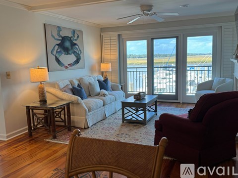 A living room with a couch, chairs, and a painting of a crab.