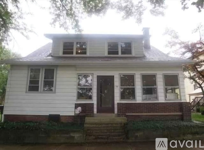 A white house with a brown door and windows.