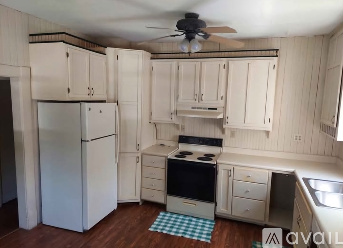 A kitchen with white cabinets and a black stove top oven.