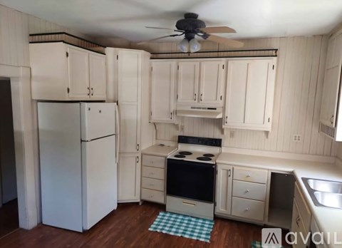 A kitchen with white cabinets and a black stove top oven.