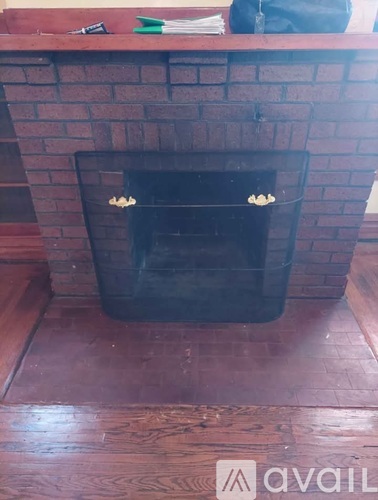 A black fireplace with a brick wall above it.