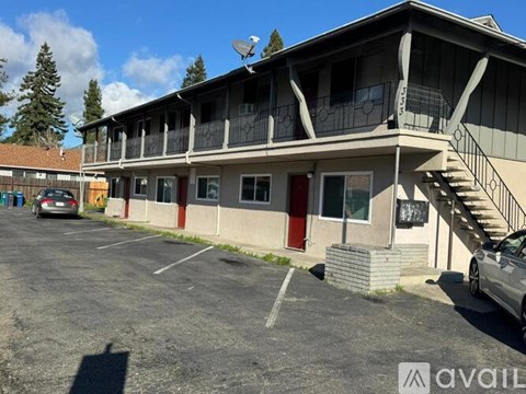 A building with a balcony and a car parked in front.