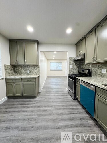 A kitchen with a marble countertop and grey cabinets.